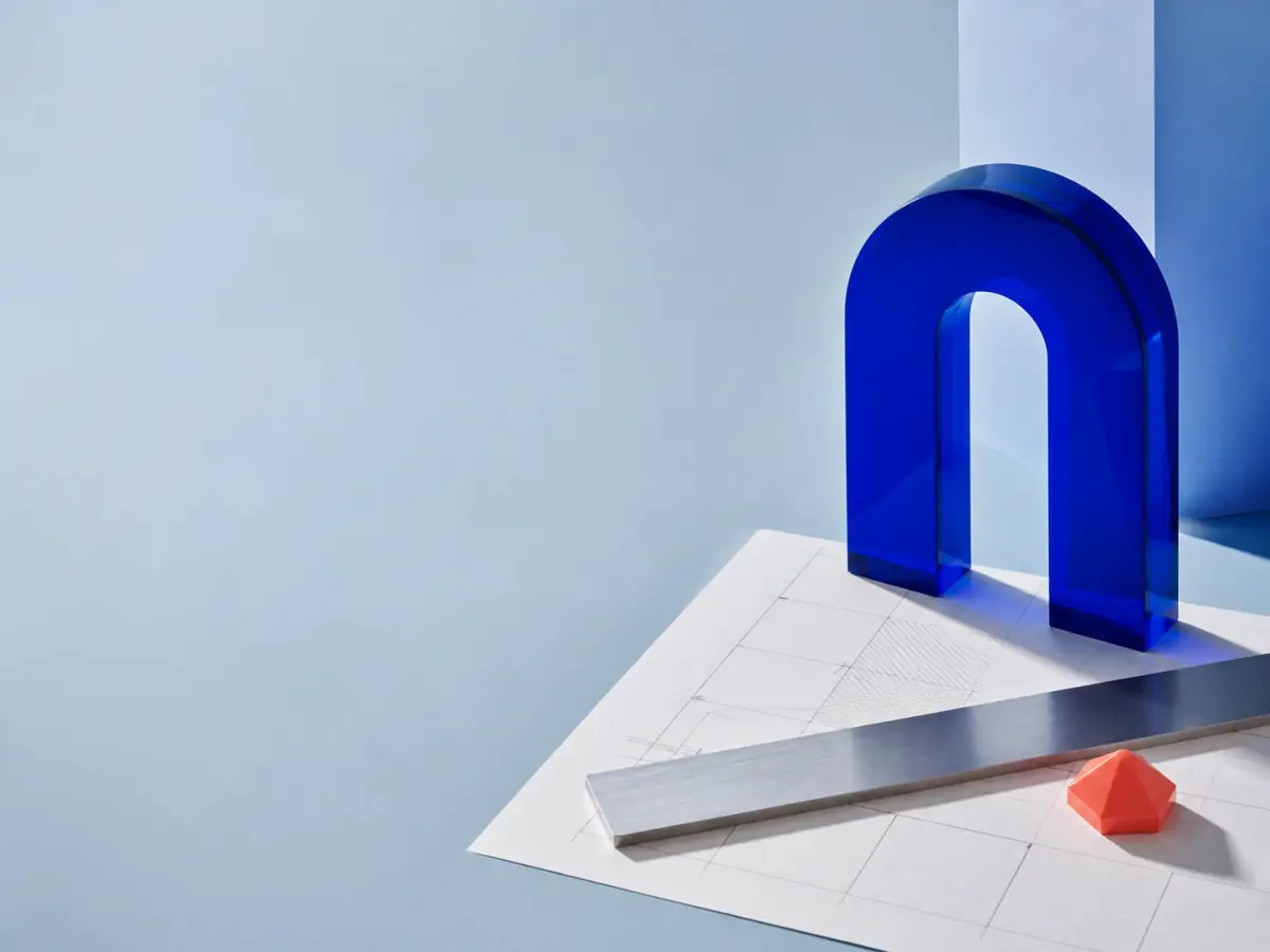 Composição editorial com arco de acrílico azul, papel arquitetônico e marcador coral